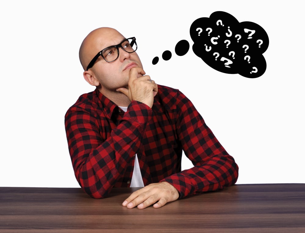 Bald man in glasses is confused by his own thoughts. Bald man in glasses is confused by his own thoughts.