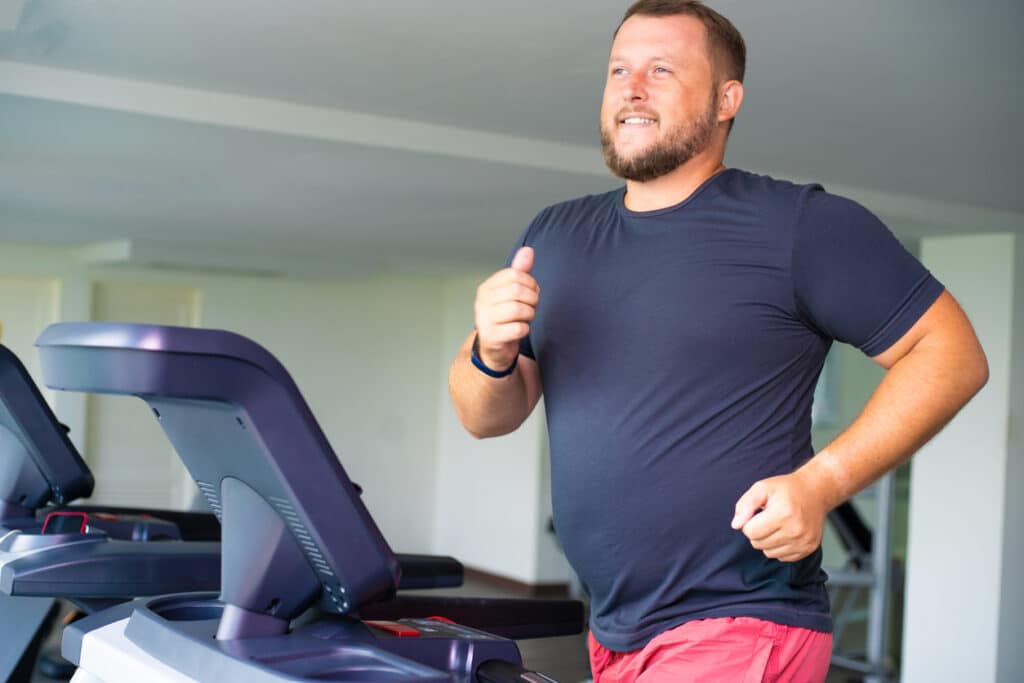 Man on a weight loss journey runs on the treadmill.