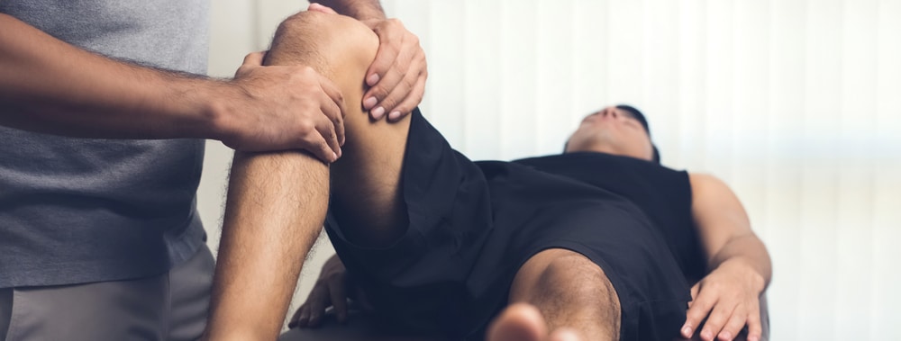 Male patient has his legs adjusted by doctor. Male patient has his legs adjusted by doctor.