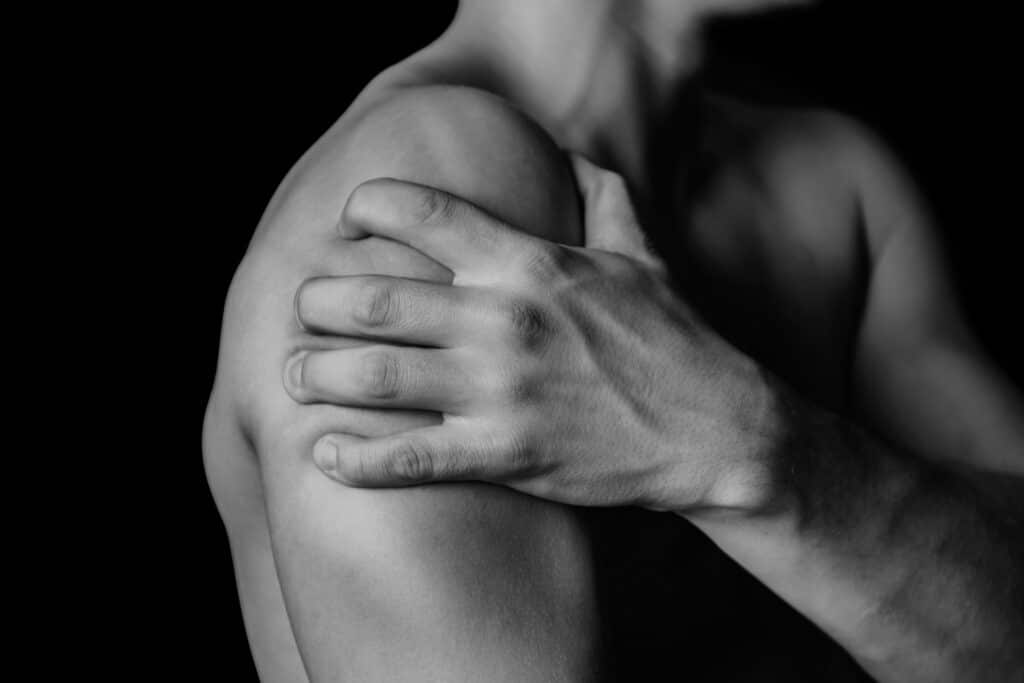 Fit black man has sore shoulders that can use recovery and therapy.